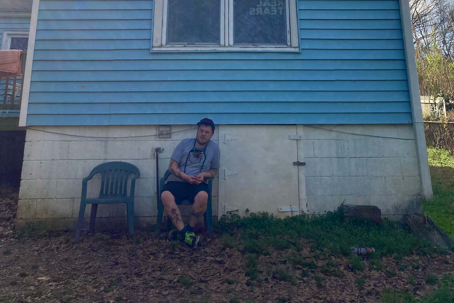 Jake Cook of Seal Pup sitting in a blue chair against a blue house