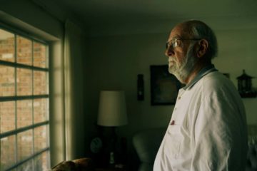 still from Easter Island video of an older man staring out of a window