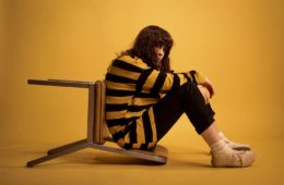 Bailey Crone of Bathe Alone sitting in a yellow room