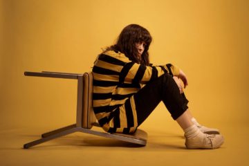 Bailey Crone of Bathe Alone sitting in a yellow room