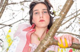 press photo of Nadia Marie in a tree holding a lemon