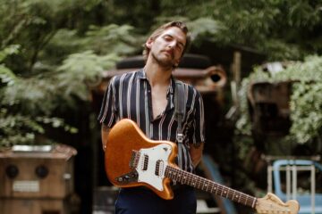 Spencer Thomas holding an electric guitar