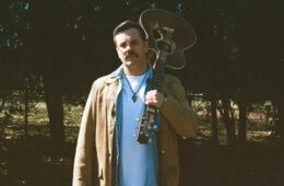 Brian Revels with an acoustic guitar flung over his shoulder