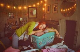 Sydney Ward of Sleepers Club leaning on a blue laundry basket
