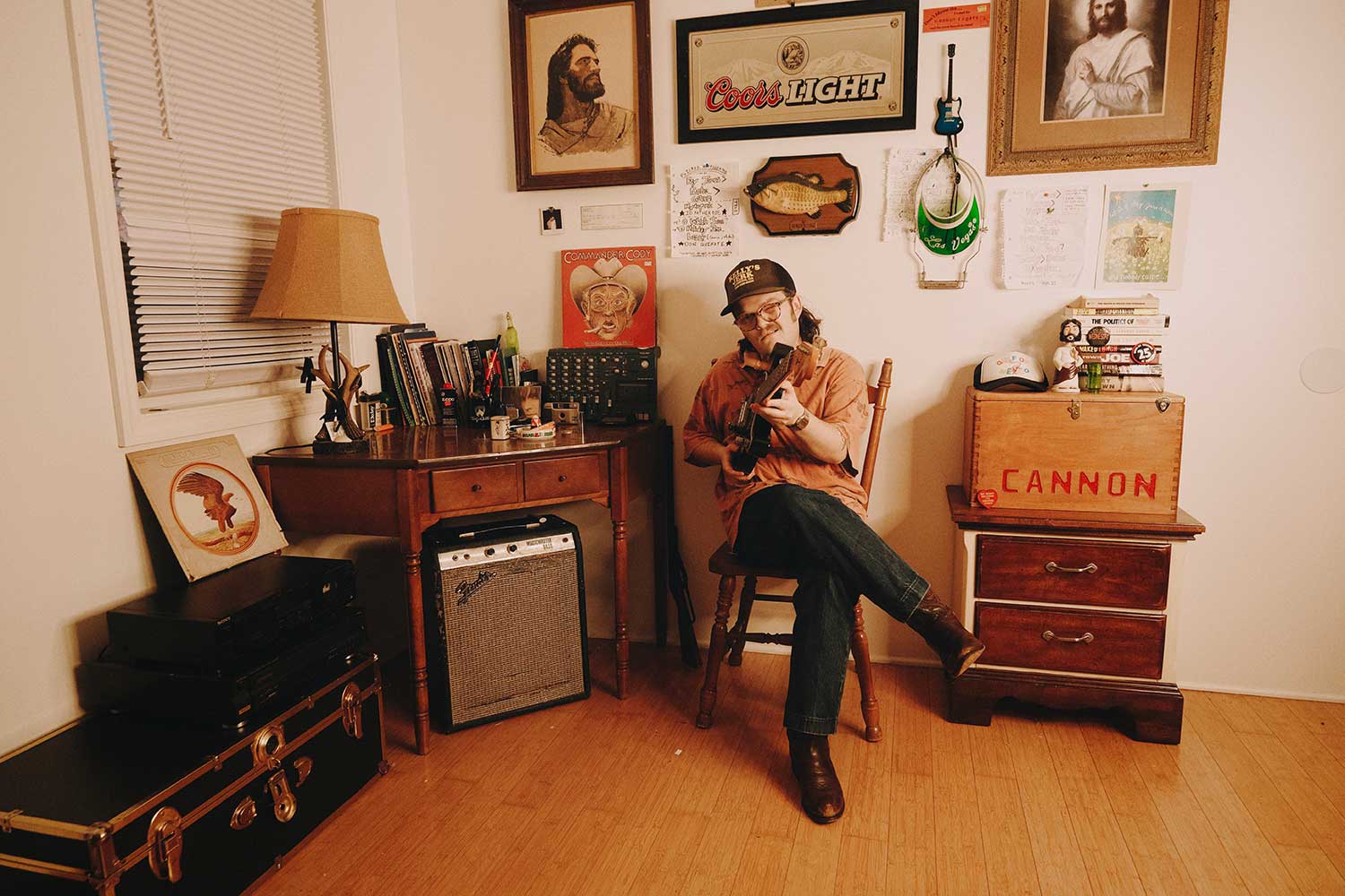 Cannon Rogers playing an acoustic guitar in his office